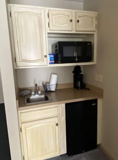 King kitchenette with microwave, fridge, glassware, plates and silverware