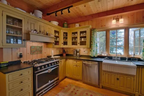 Modern country kitchen with six-burner stover, farmhouse sink and dishwasher.
