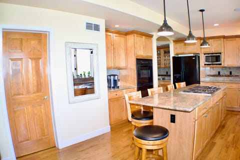 Large pantry, coffee station, dry bar, and central cooktop.