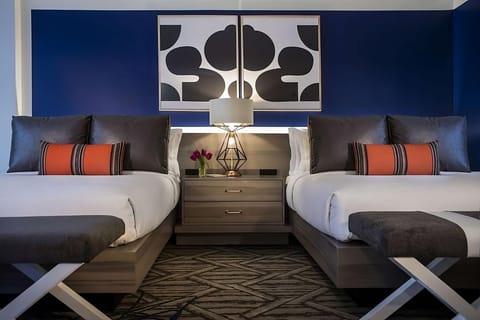 Drift off in plush beds with glowing bedside ambiance.