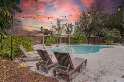 Sunset-lit backyard pool framed by lush greenery, perfect for a refreshing dip at golden hour.