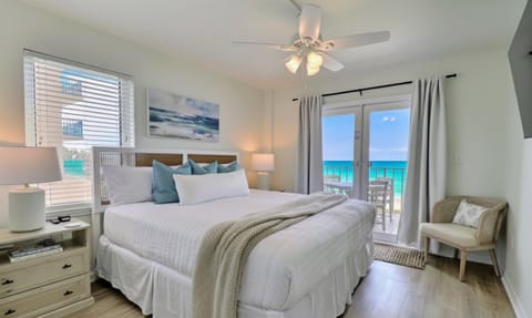 Primary bedroom facing the Gulf with balcony access. Features a king size bed