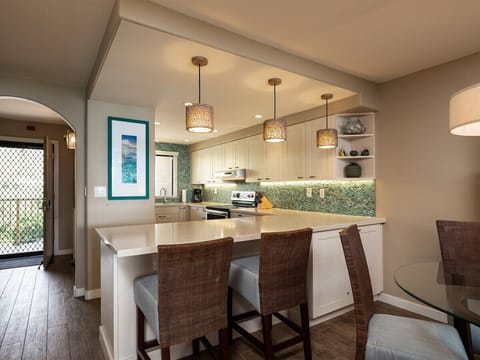 Gather, cook, and connect! This inviting kitchen and bar area, featuring a cool backsplash, is ready for your ultimate vacation.