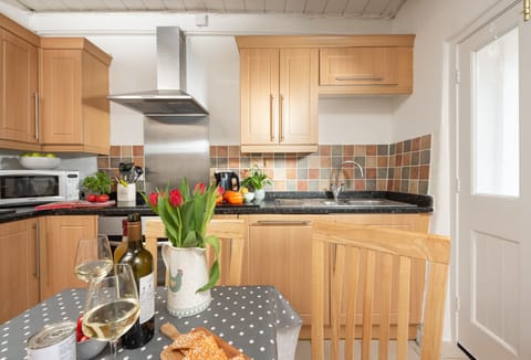 The well equipped kitchen with electric oven and hob, fridge/freezer, microwave and dining table for four.