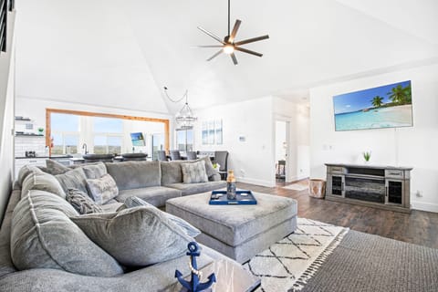 The front living area is complimented by a smart television and another sectional sofa for large groups to gather