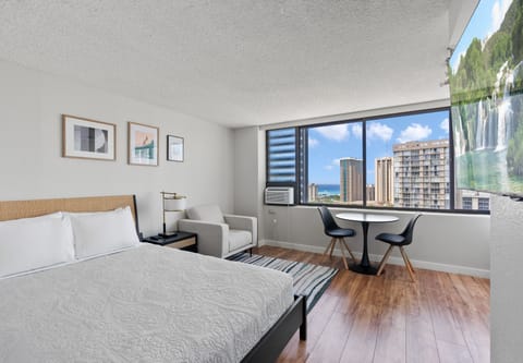 Room picture with view of Ala Wai Canal, queen bed, and dining t
