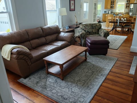 Living room area with couch, comfortable chair with ottoman, TV and coffee table