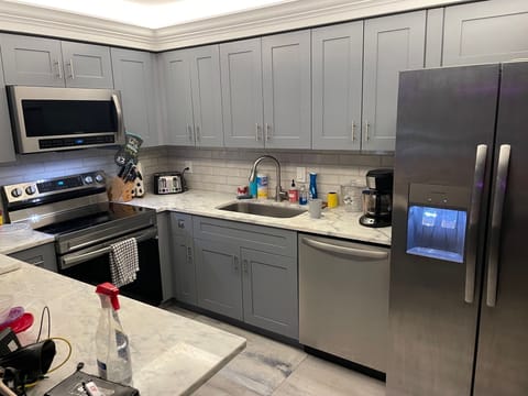 Brand new kitchen with appliances, toaster, coffee maker, microwave, ice maker.