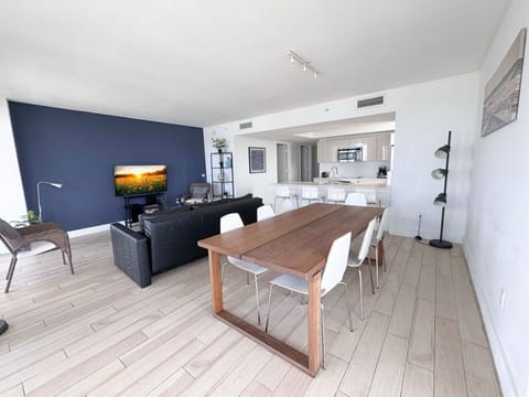 Modern dining area connected to a fully equipped kitchen. and living room