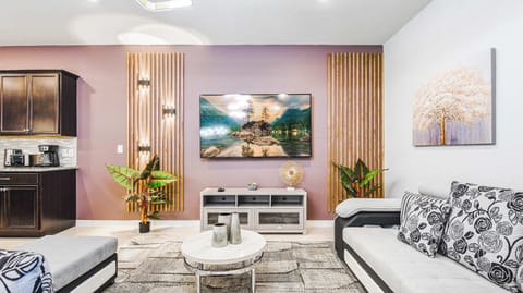 Chic living area with modern decor, cozy seating, and a large smart TV centerpiece.