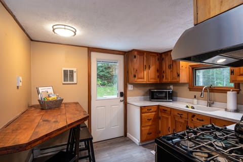 The kitchen offers an additional wooden table with stools