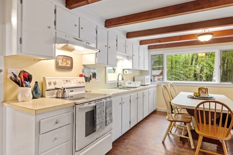 The kitchen space has large windows allowing the sun to shine