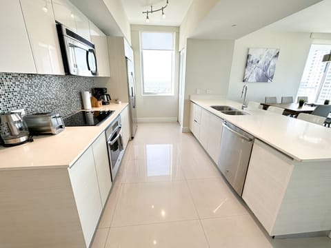 Fully equipped kitchen with stainless steel appliances and a stylish backsplash.