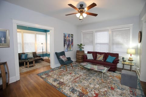 Relax in the spacious living room featuring a pop of red and local art.