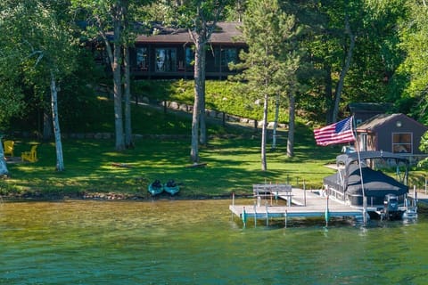 A peaceful lakeside retreat with private dock, kayaks and firepit. Surrounded by towering trees and lush lawns, this classic cabin on Lake Ossawinnamakee