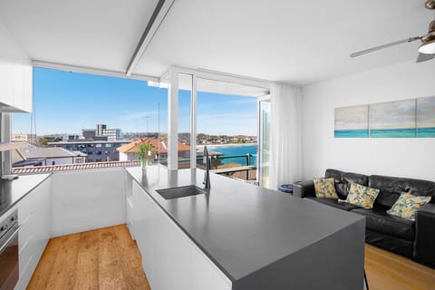 Kitchen and living looking out over balcony and views of Bondi Beach
