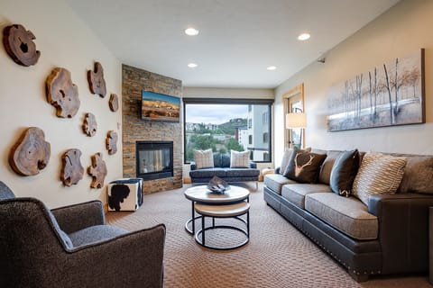 Sink into plush seating by your stone fireplace while mountain views frame your perfect retreat.