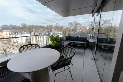 Private balcony with outdoor seating overlooking the historic Ville-Haute skyline, perfect for morning coffee or evening wine