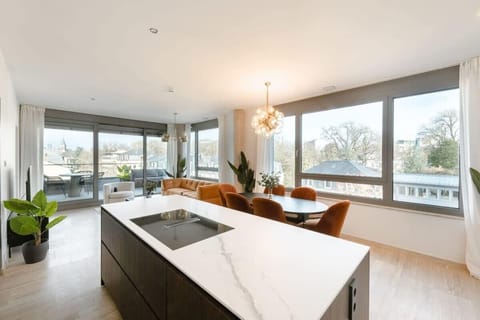 Spacious open-plan kitchen and dining area with large windows offering natural light and sweeping city views