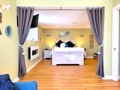 The bedroom has a TV and a beautiful electric fireplace. 