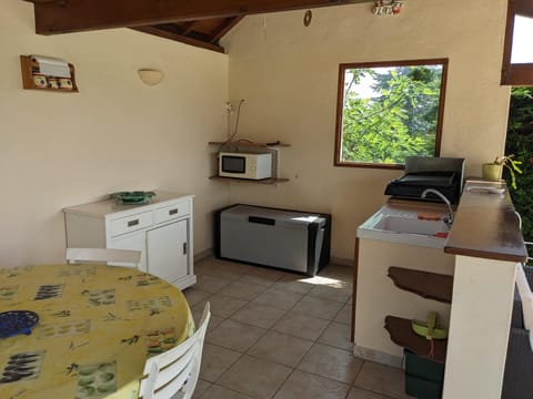 Summer kitchen next to the pool with plancha BBQ, Fridge, Microwave and sink.