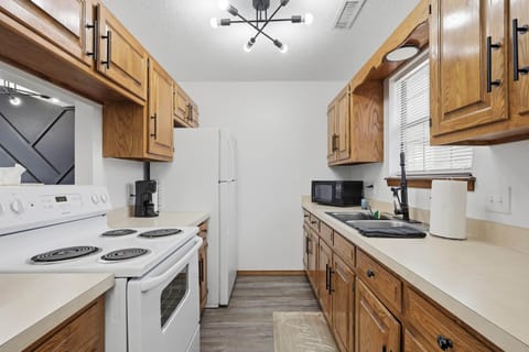 Full galley kitchen with electric range, microwave and full size fridge