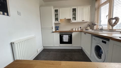 The kitchen features fridge freezer, electric hob, washing machine and microwave