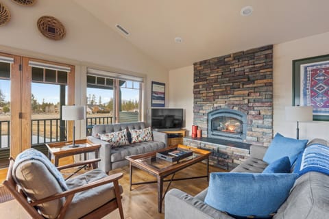 Unwind in your spacious living room where the stone fireplace crackles warmly and picture windows frame mountain views, perfect for cozy evenings together.