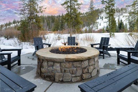 - Gather around the outdoor fire pit with mountain views   - Cozy Adirondack chairs perfect for evening relaxation   - Winter getaway atmosphere with snow covered pines