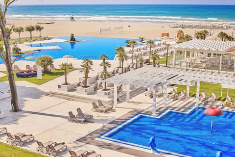 Soak up resort energy with pools, loungers, and beach ahead.