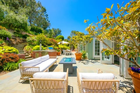Step out from the primary suite to this serene backyard retreat with lush greenery and stylish lounge seating.