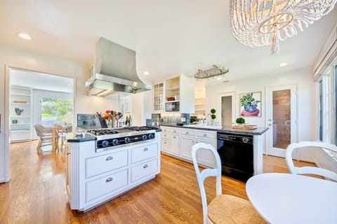 Fully equipped chef’s kitchen featuring granite countertops, premium appliances, and open sightlines to the dining room.