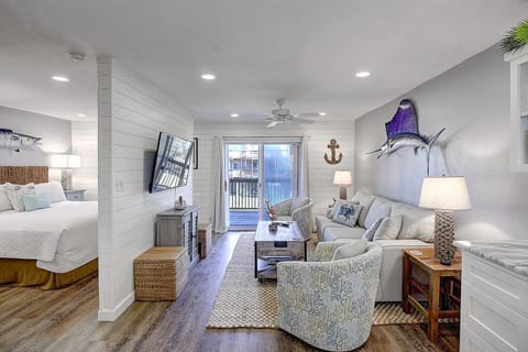 Your coastal-themed suite seamlessly blends bedroom and living spaces, featuring nautical artwork and comfortable seating for ultimate relaxation.