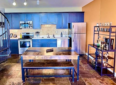 Fully Equipped Modern Kitchen
Cook with ease in this well-stocked kitchen featuring navy cabinetry, stainless steel appliances, and a warm, inviting dining area. Ideal for casual breakfasts or dinner gatherings.