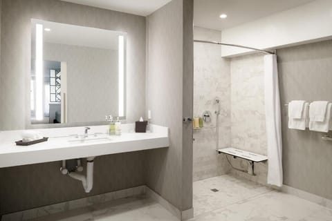 Step into a spacious walk-in shower with sleek stone tile.