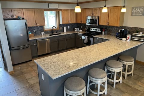 Main level kitchen, fully equipped with SS appliances, dishes, and cooking items
