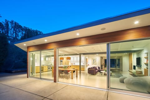 floor- ceiling sliding doors frame views of surrounding hillside & redwood trees