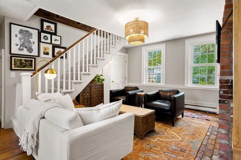 Living room with smart TV, couch, accent chairs and dedicated "work-from-home" desk. The fireplace is inoperable.