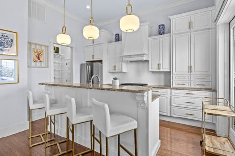 Step into your elegant kitchen with marble counters, premium appliances, and stylish pendant lighting perfect for cooking memorable meals.