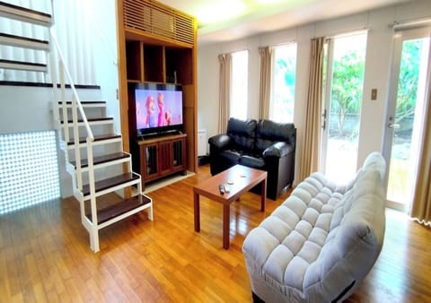 The spacious living room is equipped with a TV, two types of sofas, and a low table, making it perfect for staying with friends or family. Large windows and glass doors let in plenty of natural light. Enjoy an extraordinary time in this comfortable and cozy space.