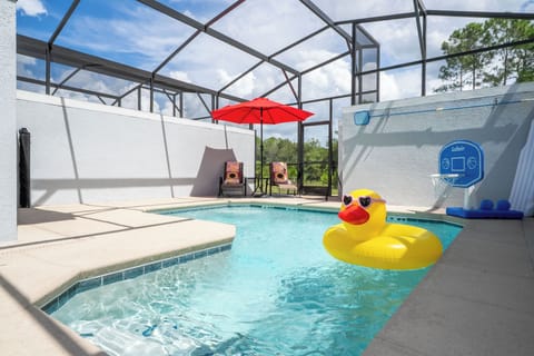 Sun-kissed fun in your private screened pool-relax under the red umbrella, lounge in the chairs, shoot some hoops, and drift on the giant duck float.
