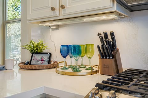 This gourmet kitchen features a large contrast-colored island with stone countertops and industrial pendant lighting. Perfect for entertaining, it offers high-end stainless appliances and seamless open-plan flow.