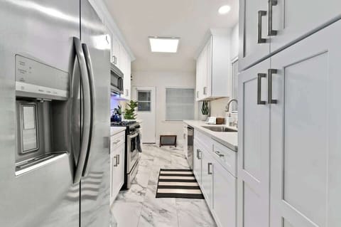 Kitchen and large refrigerator, providing ample storage for your culinary delights, ensuring your ingredients remain fresh and easily accessible throughout your stay...