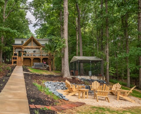 Backyard with covered porch, hot tub, firepit, and kennel