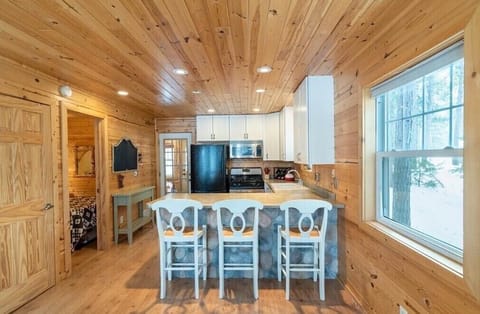 A fully equipped kitchen with breakfast bar seating, ideal for cozy meals and casual conversations.