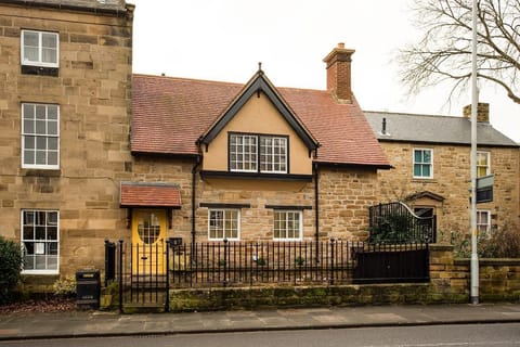 The Craftsman's Cottage - exterior view of property with its vibrant yellow front door