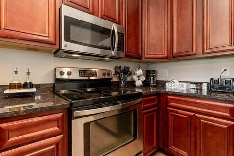 Prepare family meals with ease using the modern stainless steel stove and oven, complemented by a built-in microwave.