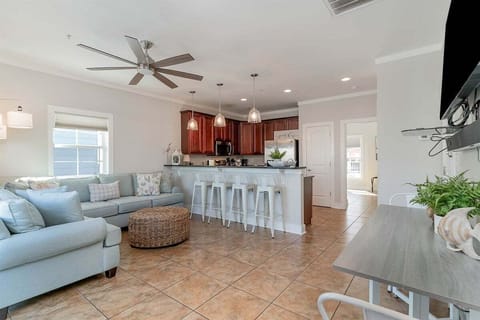 The spacious main level offers an open floor plan with a comfortable sectional, breakfast bar seating, and a versatile dining area.