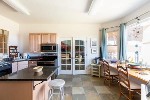 French doors on both sides of the kitchen, plus a view of the yard and field.