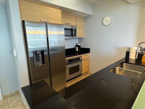 Fully equipped kitchen with stainless steel appliances and a stylish backsplash.